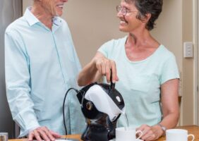 Couple smiling with kettle pouring