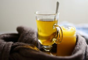 Clear glass with honey tea and spoon