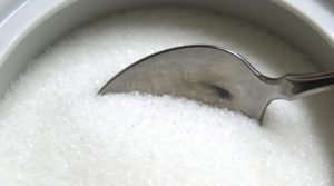 Spoon dipping into small bowl of sugar