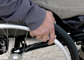 Hand holding wheelchair wheel