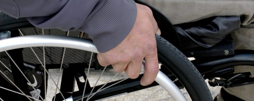 Hand holding wheelchair wheel