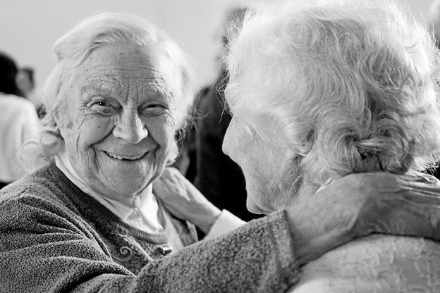 elderly women touching shoulders