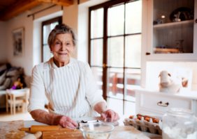 Elderly woman with arthritis baking in her kitchen