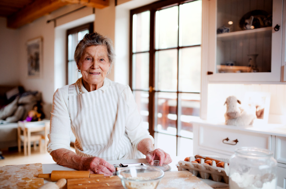 Elderly woman with arthritis baking in her kitchen