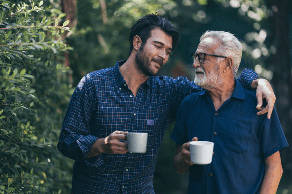 Fther and son in the garden drinking tea together