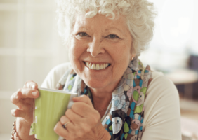 Elderly woman drinking a cup of green tea