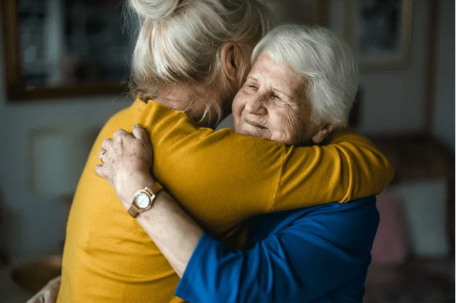 Elderly mother hugging your adult daughter