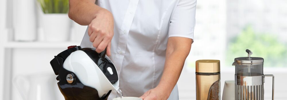 Woman using the tilt-to-pour action of the Uccello Kettle