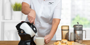 Woman using the tilt-to-pour action of the Uccello Kettle