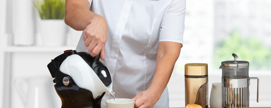 Woman using the tilt-to-pour action of the Uccello Kettle