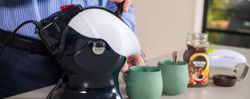 Elderly man pouring the Uccello Kettle in the kitchen